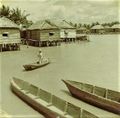 Dugout canoes and huts on wooden piles on Rio Limon