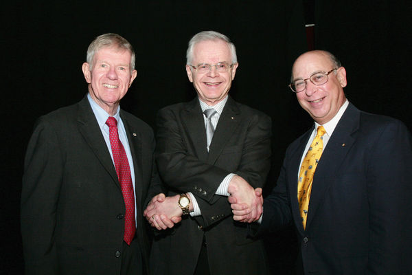Handshakes after the signing of the Eta Kappa Nu merger agreement; Richard Gowen, John Vig and Bruce Eisenstein.